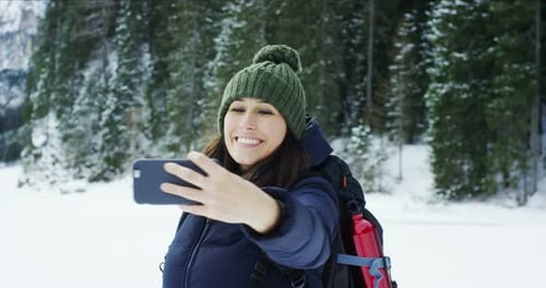 Happy Woman Taking Selfie in Snowy Winter Forest
