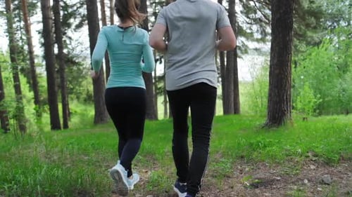 Sportive young people running. Couple run in the park during the day
