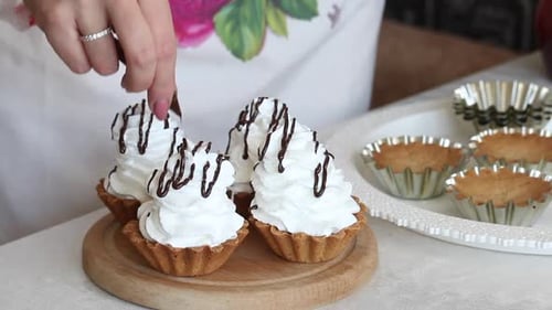 A Woman Puts Chocolate On Buttercream. From A Pastry Bag. Makes A Cake Basket. Close Up