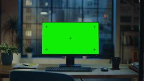 Desktop Computer with Mock-up Green Screen Standing on the Wooden Desk in the Modern Creative Offic