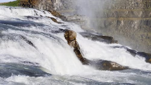 Rushing Waterfall Cascading Over Rocky Terrain