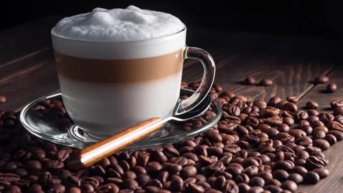 Frothy Latte with Coffee Beans on Wooden Table