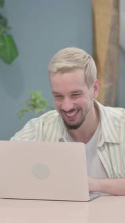 Cheerful Young Adult Man Video Calling on Laptop