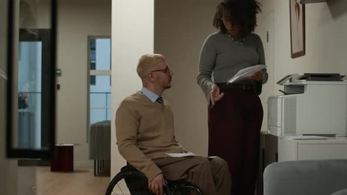 Office Worker in Wheelchair and Female Colleague Copying Documents on Printer
