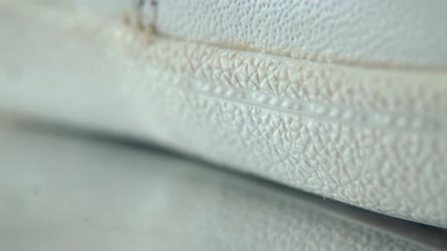 A close-up shot of a white sneaker sole, miniature shoe display on a 360 rotating stand with reflect