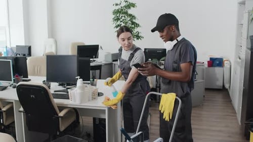 Cleaning Crew Smiles while Working in Office