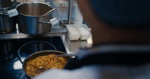 Chef Stirring Spaghetti with Red Sauce in Pan