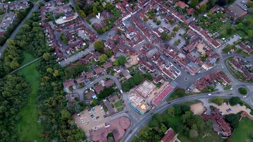 aerial Birds Eye drone shot over Bishops Waltham at sunset in autumn with roads, trees and houses