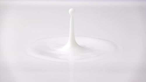 Goutte de lait frais qui tombe et éclabousse dans une mare laiteuse depuis le haut (anneaux au ralenti et sommet ondulé)