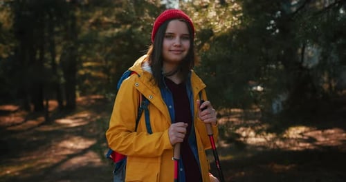 Backpacker Hiker Girl with Hiking Poles Walking Between Trees in a Mountain Forest Hispanic Teenager