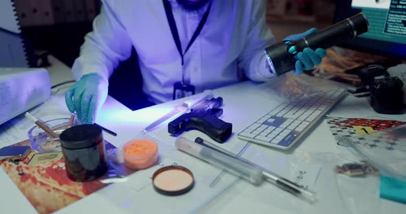 Hands, forensics and evidence at lab for weapon inspection with uv ...
