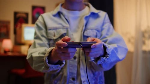 Person Playing Video Game with Wired Controller Indoors