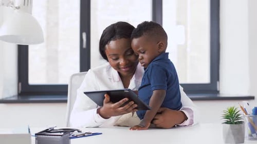 Doctor and Child Patient Looking at Tablet Screen
