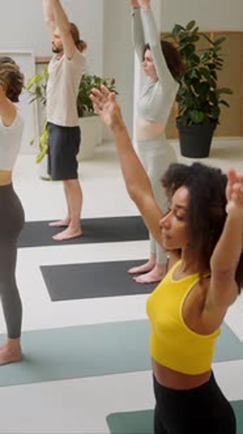 Grupo de pessoas fazendo exercícios respiratórios no estúdio de ioga