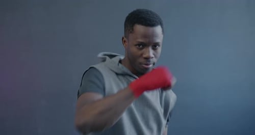 Man Practicing Boxing Punches with Red Hand Wraps