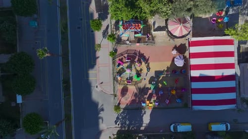 Aerial Video Small Park with Old Worn Swings and Charming Vintage Rides Captured From Above