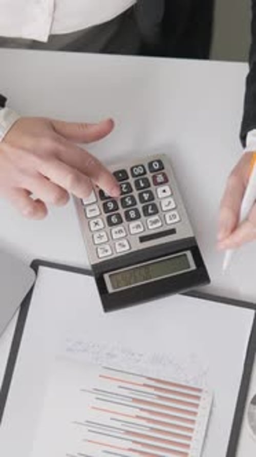 Un espace de travail professionnel comprenant une calculatrice pour ordinateur portable et divers documents financiers conçus pour