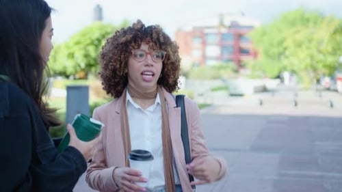 Two Women Chatting Outdoors on a City Street