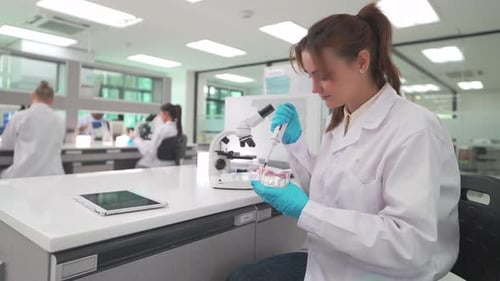 Focused woman works in bright modern laboratory