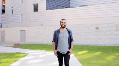 Lifestyle, Leisure and People Concept - Smiling Man Walking Along City Street Active