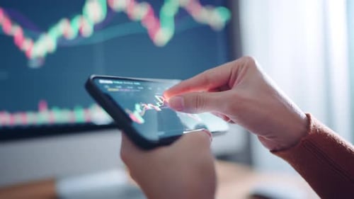 Woman is checking Bitcoin price chart on digital exchange on smartphone