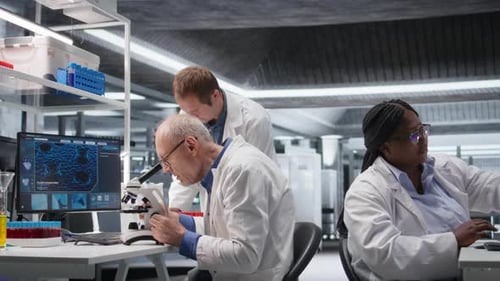 Laboratório com velho cientista masculino observando espécimes sob microscópio