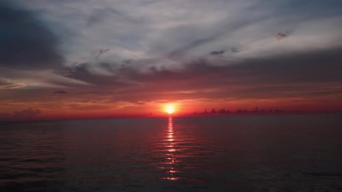 Dramatic Ocean Sunset Burning Sky and Shining Golden Waves Ocean Beach Sunsets Wide Drone Shot
