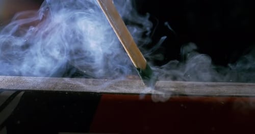 Burning matchstick close-up on a dark background. Shot on super slow motion camera 1000 fps.