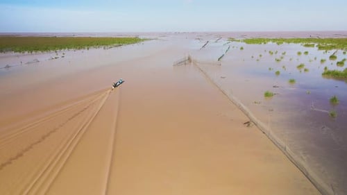 Aerial drone follow fishing boat motoring past arrow headed fish traps on the Tonle Sap, the largest