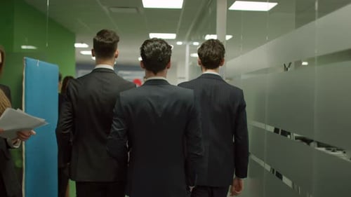 Professionals Walking in Office Hallway in Suits