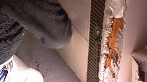 Person Installing a Ceramic Tile Indoors