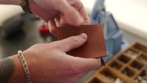 Leather Craftsman Works in Workshop Master Making Leather Wallet Man Installs Tack Button Snap