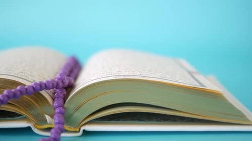 Heiliges Buch, Koran und Rosenkranz auf dem Tisch, Nahaufnahme