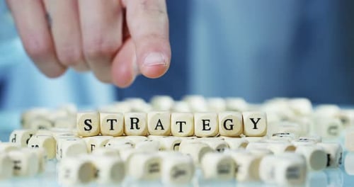 Slow motion macro of the word "Strategy" of the wooden letter blocks . Concept of financial market