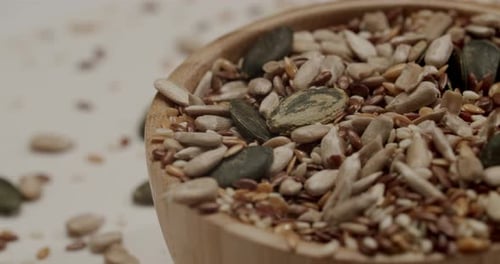 Healthy Seeds Mix Falling Into a Wooden Bowl