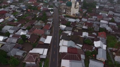 Luftaufnahme von Dorf, Moschee, Straße, Häusern im Nebel, Indonesien.