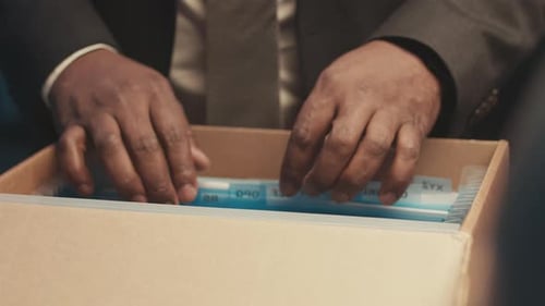 Person Sorting Through Files in Box