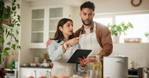 Couple Using Tablet to Cook Together at Home