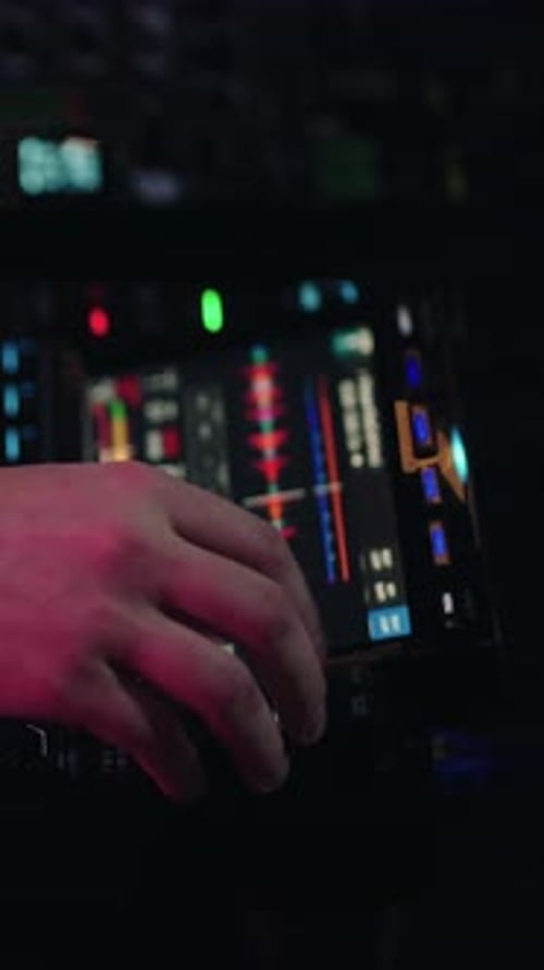 Hand Adjusting Audio Mixer in Dark Recording Studio