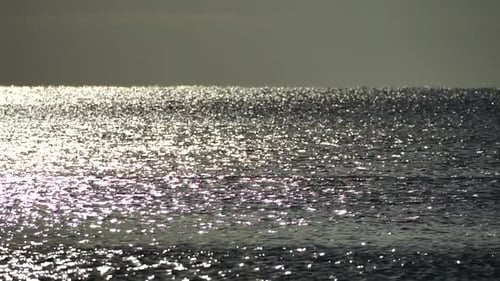 Abstrakte strahlende Sonnenreflexionen auf der blauen Oberfläche von Meereswellen