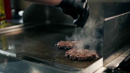 Professional restaurant kitchen close-up of delicious juicy patties on the grill for a smash burger