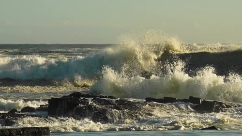 Rough Sea Waves Crashing On Rocky Shoreline Creating Huge Spray and Foam - Medium Pan Shot