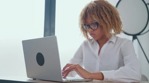 Woman Typing on Laptop in Bright Modern Office