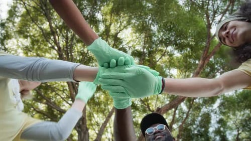 Team of Volunteers Joining Hands in Park