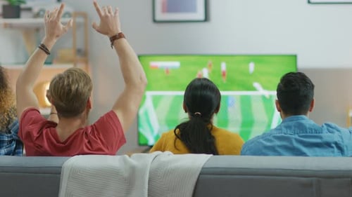 Friends Watching Soccer Match on TV in Living Room