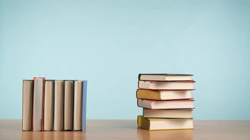 Stop Motion of Colorful Old Books Being Moved From a Stack to a Row and Back Again on a Wooden Table