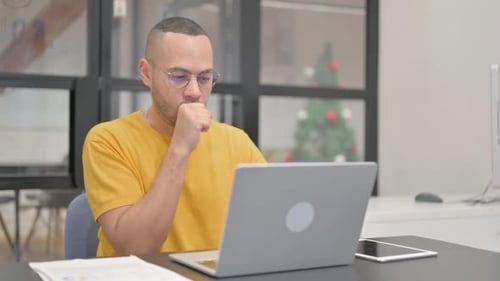 Man Works on Laptop, Thinking in Bright Office