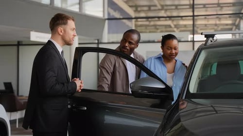 Car Salesman Talks to Couple About New Car