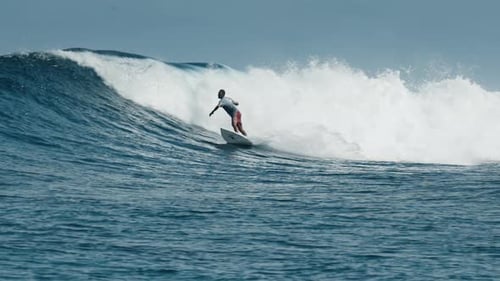 Surfer Rides Ocean Wave in the Maldives