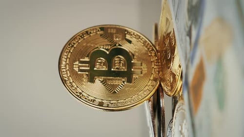 BTC. Goldene Bitcoins rotieren auf glänzendem Hintergrund der Bitcoins. Vertikales Video